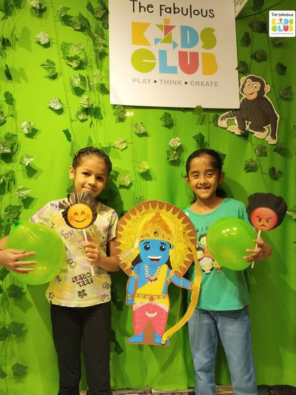 Two friends proudly hold up props from our Ramkatha storytelling session. We use engaging visuals to bring traditional stories to life for the children.