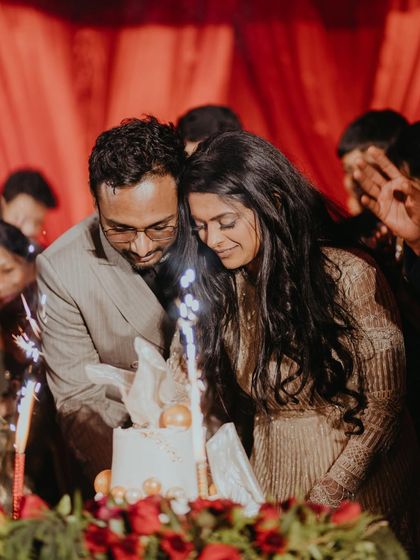 The cake-cutting ceremony during the Sangeet. Surrounded by sparklers and loved ones, this is a moment of pure celebration and the start of a sweet life together.