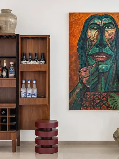 This custom bar cabinet in Apartment 1600 is a perfect example of functional art. Designed to host and entertain, it combines elegant wood fluting with ample storage, complemented by bold artwork to create a vibrant social corner in this bachelor pad.