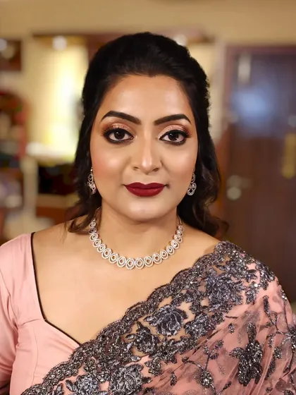 A frontal portrait showing the classic makeup look: defined eyes, bold lips, and a clean base.