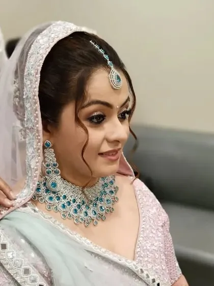 A side view of the messy bun, showing the soft tendrils that frame the face. This adds a touch of romance to the overall bridal look.