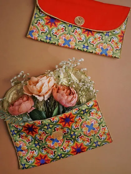 These beautifully patterned pouches are styled with delicate flowers, creating a soft and feminine aesthetic. One pouch is open with flowers spilling out, adding a touch of whimsy and life to the shot.