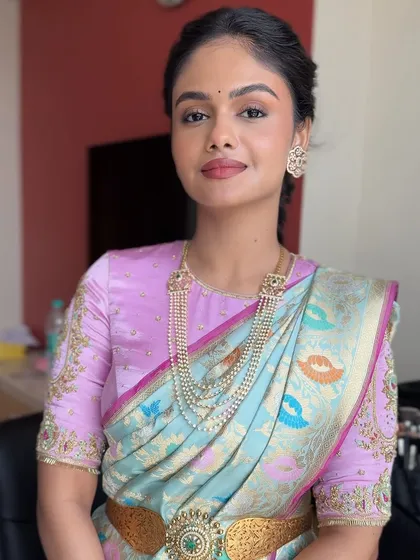 The bride looking radiant with her floral braid. This hairstyle perfectly complements her pastel lehenga and glowing makeup.