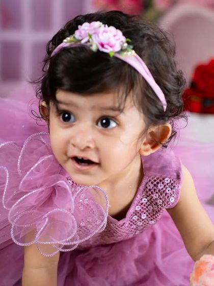 The magic of a smile is captured perfectly in this close-up of a little girl in a beautiful lavender dress.
