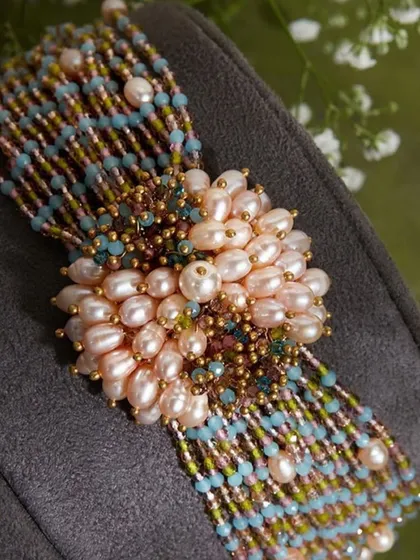 A choker that matches everything in your closet. This piece is handcrafted with a cluster of freshwater pearls and colourful beads.