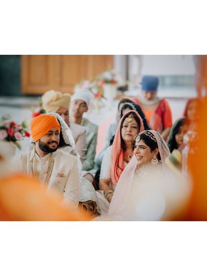 A candid shot of Suraj and Kajal during their Sikh wedding ceremony, with their families watching on with love.