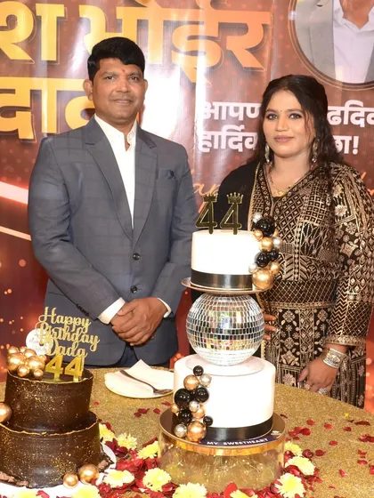 Another photo from the 44th birthday celebration, showing the couple and their impressive cake setup.