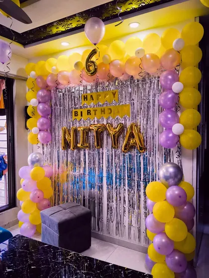 A yellow and purple balloon arch for a 6th birthday, creating a bright and cheerful party atmosphere.