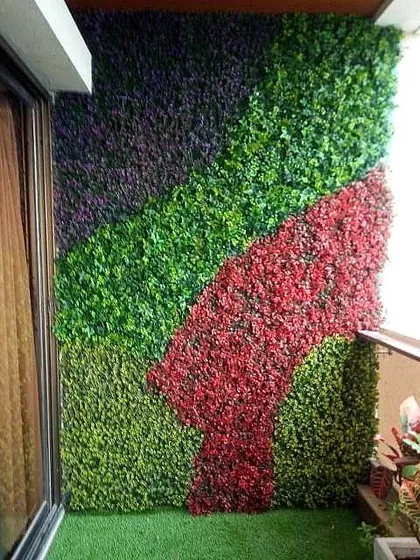 This custom designed artificial green wall for a balcony uses bold blocks of color to create a modern, artistic look. It's a great way to add personality to a small outdoor space.