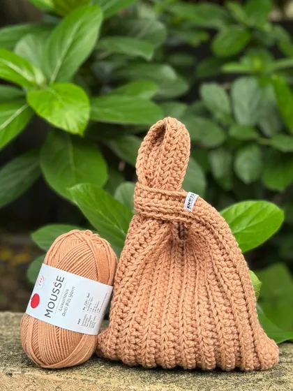 The finished Japanese knot bag next to the ball of mousse-colored yarn it was made from. I love seeing a project come to life from a single strand of thread.