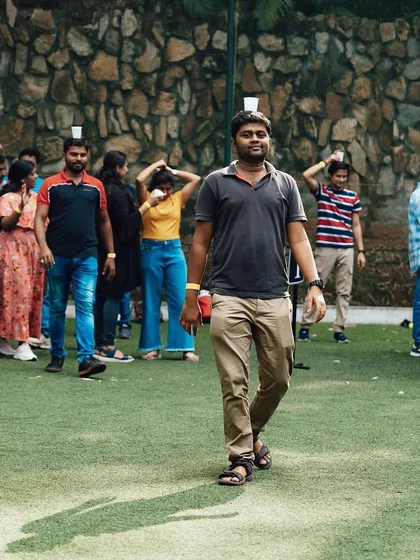 The Pyramid Builder is a crowd favorite for a reason. Here, a team member carefully walks while balancing a cup on his head.