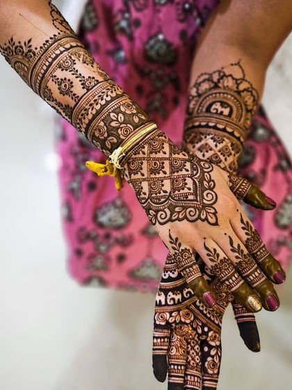 A beautiful bridal design with a focus on geometric grids on the back of the hand, contrasted with softer floral patterns on the arm.