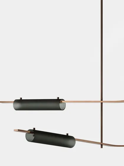 A detailed view of the Volant system with blackened brass and smoked glass finishes, showcasing the sophisticated material options.