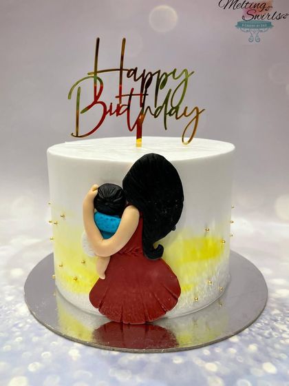 A simple and heartfelt cake for a new mom, featuring a handmade fondant figure of a mother holding her baby.