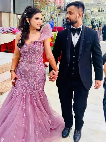 We love helping couples coordinate their looks. She is dazzling in a pre-owned lavender fish-cut gown with intricate floral embroidery, while he looks sharp in a classic black tuxedo. Find your perfect pair of outfits with us.