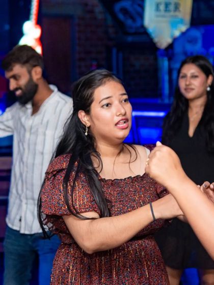 A guest caught in the middle of a dance move. The blue lights and energetic crowd make for a great party atmosphere.