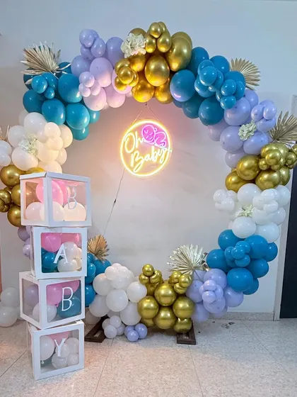Another angle of the "Oh Baby" setup, showing the beautiful mix of teal, lavender, white, and gold balloons. The dried pampas leaves add a trendy, bohemian touch to the balloon arch.