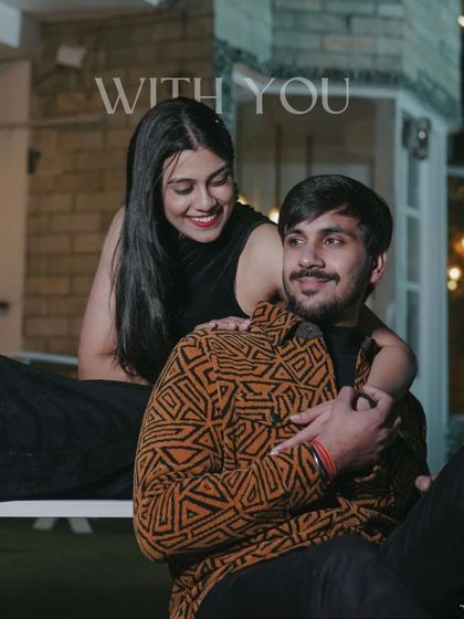 A happy, smiling portrait of a couple sharing a candid moment at night, with warm lights creating a cozy and intimate atmosphere.