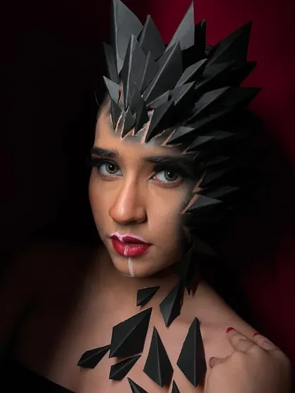 This shot highlights the contrast between the sharp black structures and the soft, blended makeup on the other side of the face.