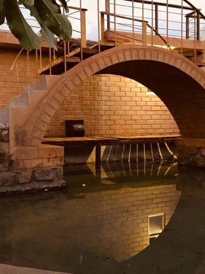 Our work isn't just about interiors; it's about creating experiences. This brick arch bridge, reflected in the water below, is an example of how we blend classic architectural principles with natural elements to build truly unique and tranquil spaces.