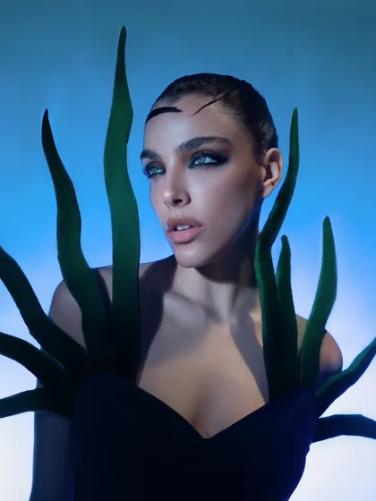 A close-up from a beauty editorial focused on creating a surreal, aquatic-inspired look. I used specific studio lighting with blue gels to craft this otherworldly mood, highlighting the sharp, graphic makeup and the model's intense gaze.