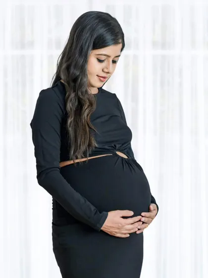 There is so much beauty in simplicity. This quiet moment, captured in a simple black dress against a soft white background, focuses on the mother's gentle connection with her baby.