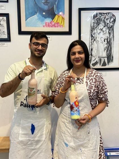 A couple with their finished decoupage bottles. It's a fun and creative way to spend an afternoon together.