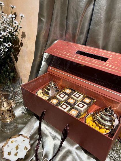 This festive box doubles as a tissue holder and is filled with sweets and dry fruits. A practical and beautiful gift for any home.