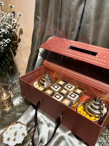 This festive box doubles as a tissue holder and is filled with sweets and dry fruits. A practical and beautiful gift for any home.