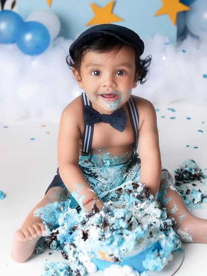 This little gentleman, complete with a dapper bowtie, is having the time of his life at his first birthday cake smash. The pure joy of this moment is just priceless.