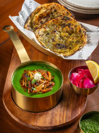 Palak Paneer with a modern twist, served with stuffed parathas for Camo Noida. The vibrant green of the spinach gravy is the hero of this shot.