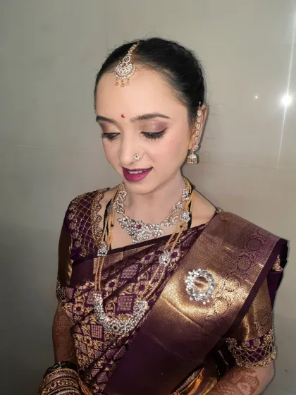 A soft and subtle makeup look for a bride's 'pujani' or post-wedding ritual. The focus is on fresh, dewy skin, gentle shimmer on the eyes, and a natural pink lip, creating an effortlessly elegant appearance.