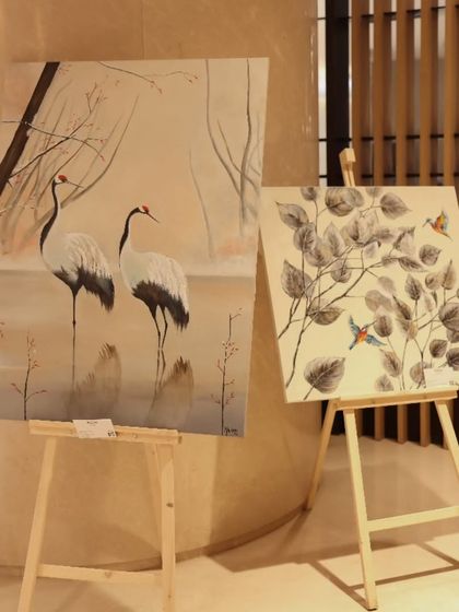 Two paintings by Malika Vijay from 'Nature's Symphony', featuring elegant cranes and birds, displayed at the Conrad Bengaluru.