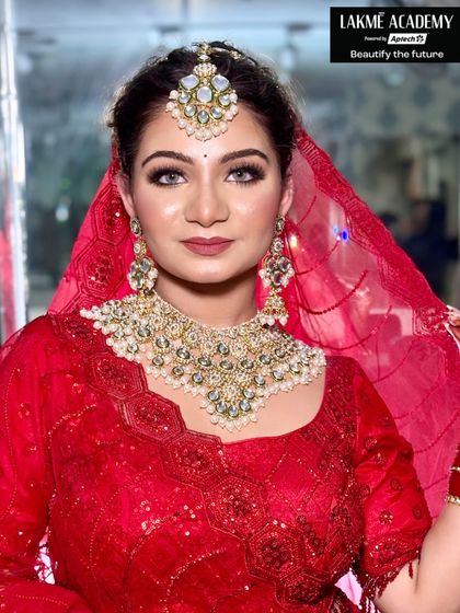 A classic red bridal look that never goes out of style. This student's work showcases a matte red lip, defined brows, and soft smokey eyes, a timeless combination taught in our foundation and advanced bridal courses.