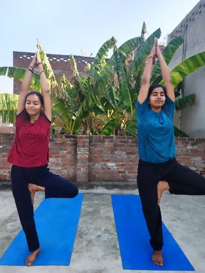 Practicing Vrikshasana (Tree Pose) side-by-side with my student. It's wonderful to see her confidence and balance grow with each session.