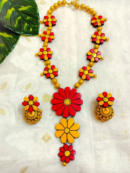 This is a beautiful three-layer long floral necklace in a classic red and yellow combination, perfect for haldi ceremonies or festive events. It comes with matching floral jhumkas.