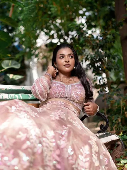 A model sitting on a bench, showcasing a modern and subtle reception look.
