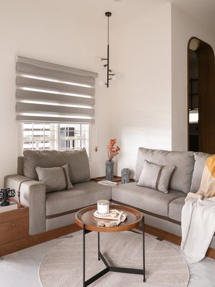 A custom-built L-shaped sofa with unique leather strap details provides ample seating in this living room. The design merges craftsmanship with function, creating a cohesive and sophisticated environment.