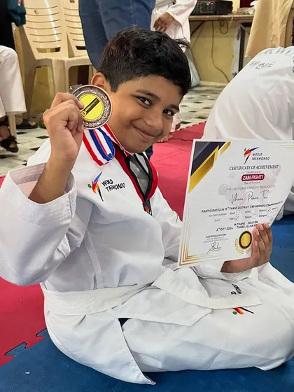 A young champion with his medal and certificate of achievement after a successful Taekwondo tournament.