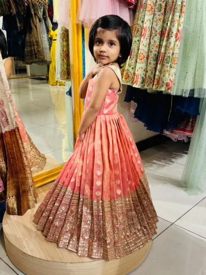 That look when you know your outfit is a 10/10. This little one is glowing in her custom-stitched peach and gold brocade frock. I designed it with a pleated skirt for extra flair, perfect for parties and festive occasions.