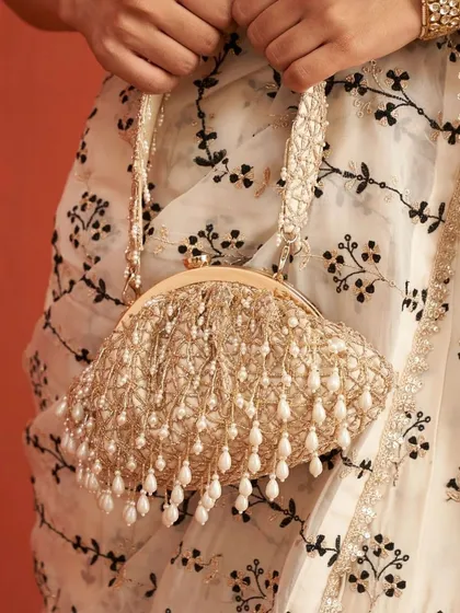 Paired with an elegant saree, this pearl-draped clutch bag adds a touch of ethereal beauty. It's the perfect accessory for a sophisticated mehendi or sangeet look.