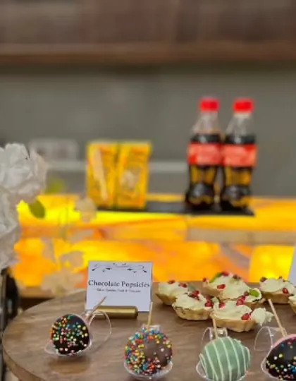 The dessert table at a 'Lolirock' party, featuring colorful chocolate popsicles and fruit tarts. Sweet treats are always a highlight of any birthday celebration.