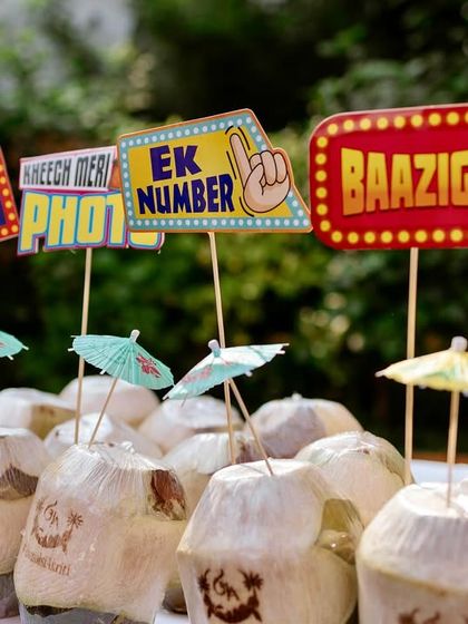It's all in the details. For a fun Mehendi, I set up interactive stations like this one with quirky Bollywood-themed props and refreshing coconut water to keep guests entertained and hydrated.
