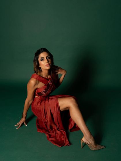 This wider seated shot for iDiva provides more context of the pose and the flow of the dress, creating an elegant and strong composition.