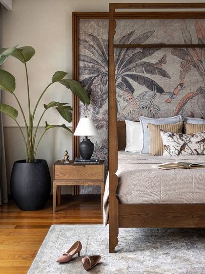 The master bedroom is a true retreat. The four-poster bed and dramatic wallpaper create a calming yet impressive focal point, while the natural light enhances the warm, layered textures.