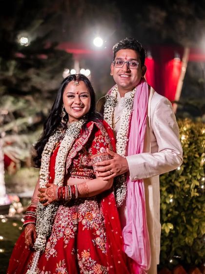 A happy couple portrait after their wedding ceremony, surrounded by the warm glow of evening lights. Their smiles truly light up the frame.