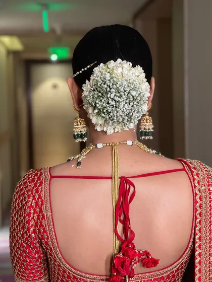This is a classic for a reason. I crafted this traditional bridal bun and adorned it with a full circle of fresh baby's breath gajra, creating a clean, elegant, and timeless look for the main wedding ceremony.