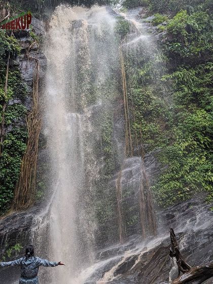 A trekker stands with arms open before the Hidlumane waterfalls on the Kodachadri trail.
