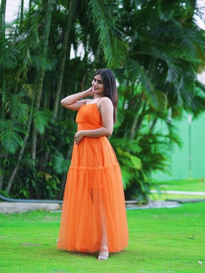 A full-length shot of the orange tulle dress, showing its simple, flowy design. It's a comfortable and stylish option for any photoshoot.