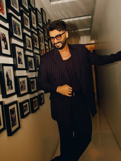 Another shot of Arjun Kapoor's look for the Netflix premiere. The relaxed yet stylish pose showcases the full pinstripe suit, which we paired with a simple chain and tinted glasses for a touch of effortless cool.